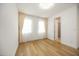 Bright bedroom with large windows, light curtains, wood flooring, and a doorway leading to the bathroom at 10455 Wet Marsh Cv, Parrish, FL 34219