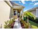 Inviting entrance with landscaped flowerbeds, a walkway and a charming front door at 10455 Wet Marsh Cv, Parrish, FL 34219