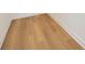 Close-up of the light brown wood flooring and white baseboards, showcasing the texture and detail at 10455 Wet Marsh Cv, Parrish, FL 34219