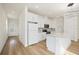 Bright kitchen features modern appliances, white cabinetry, stylish backsplash, and a central island with a sink at 10455 Wet Marsh Cv, Parrish, FL 34219