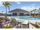 Community pool with lounge chairs and a large pavilion in the background at 10455 Wet Marsh Cv, Parrish, FL 34219