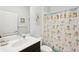 Comfortable bathroom featuring a vanity sink and a shower with tropical themed curtain at 12676 Sagewood Dr, Venice, FL 34293
