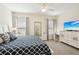 Bedroom featuring a large bed, dresser with TV, and a desk, bathed in natural light at 12676 Sagewood Dr, Venice, FL 34293