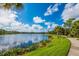 Community lake with a walking path, lush greenery, and a serene water view under a bright sky at 12676 Sagewood Dr, Venice, FL 34293