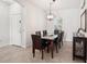 Bright dining room features stylish chandelier and a dining table with comfortable leather chairs at 12676 Sagewood Dr, Venice, FL 34293