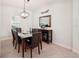 Bright dining room features stylish chandelier, dining table with leather chairs, and handsome sideboard at 12676 Sagewood Dr, Venice, FL 34293