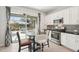 Modern kitchen with white cabinets, stainless steel appliances, and a breakfast nook overlooking the water at 12676 Sagewood Dr, Venice, FL 34293