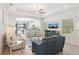 Bright living room with a ceiling fan, an archway to the kitchen, and tile flooring at 12676 Sagewood Dr, Venice, FL 34293