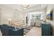 Bright living room with a ceiling fan, an archway to the kitchen, and tile flooring at 12676 Sagewood Dr, Venice, FL 34293