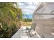 Serene patio with lounge chair overlooking lush greenery and a tranquil lake at 12676 Sagewood Dr, Venice, FL 34293