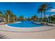 Relaxing zero-entry community pool surrounded by palm trees and covered seating areas at 12676 Sagewood Dr, Venice, FL 34293