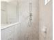 Detailed view of a modern shower with marble tile, a sleek shower head, and built-in soap dish at 12676 Sagewood Dr, Venice, FL 34293