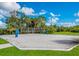 Sandy volleyball court with net set up surrounded by trees and greenery on a sunny day at 12676 Sagewood Dr, Venice, FL 34293