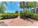 Landscaped backyard featuring a brick paver patio and manicured shrubbery at 12838 Daisy Pl, Bradenton, FL 34212