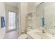 Bright bathroom with neutral tiles, a single vanity, and access to the shower and patio at 12838 Daisy Pl, Bradenton, FL 34212