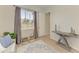 Bright bedroom featuring a window, neutral walls, decorative rug and table, and light-colored, wood-look flooring at 12838 Daisy Pl, Bradenton, FL 34212