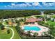 Aerial view of community pool and clubhouse surrounded by beautiful landscaping and playground at 12838 Daisy Pl, Bradenton, FL 34212