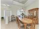 Formal dining area with elegant wooden table and chairs, bathed in natural light from a large window at 12838 Daisy Pl, Bradenton, FL 34212