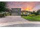 Charming two-story home with lush landscaping, a paver driveway, and a tile roof set against a colorful sunset at 12838 Daisy Pl, Bradenton, FL 34212