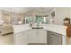 Bright kitchen featuring white cabinetry, stainless steel appliances, and a view of the pool area at 12838 Daisy Pl, Bradenton, FL 34212