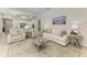Spacious living room with neutral tones, tile floors, view to the kitchen, and stylish furniture at 12838 Daisy Pl, Bradenton, FL 34212