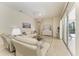 Open living room with bright neutral tones, lanai access, and comfortable seating arrangement at 12838 Daisy Pl, Bradenton, FL 34212