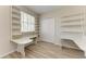 Home office features two built-in desks with matching shelving units, hardwood floors, and a window for lots of natural light at 12838 Daisy Pl, Bradenton, FL 34212