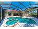 Gorgeous screened-in pool and spa with plenty of patio space and a relaxing view of the home and greenery at 12838 Daisy Pl, Bradenton, FL 34212