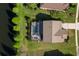 Aerial view of a home with a screened-in pool, surrounded by greenery and adjacent to a pond at 13116 Bliss Loop, Bradenton, FL 34211