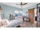 Bedroom with light blue walls, barn door access to the bathroom, and views of the neighborhood at 13116 Bliss Loop, Bradenton, FL 34211