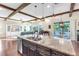 This kitchen features an island with granite countertops, an adjacent living area, and a view of the backyard at 13116 Bliss Loop, Bradenton, FL 34211