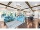 Open-concept living area with wood beam ceilings, hardwood floors, and modern kitchen at 13116 Bliss Loop, Bradenton, FL 34211