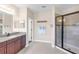Bright bathroom with a walk-in shower with black trim, dual sinks, and access to the commode at 13116 Bliss Loop, Bradenton, FL 34211