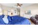Main bedroom features a large bed with a blue comforter, wood-look floors, and a view of the bathroom at 13116 Bliss Loop, Bradenton, FL 34211
