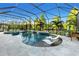 Stunning screened pool area with waterfall feature, hot tub, and lounge chairs at 13116 Bliss Loop, Bradenton, FL 34211