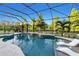 Screened-in pool with water feature, hot tub, tanning ledge and view of pond and wooded area at 13116 Bliss Loop, Bradenton, FL 34211