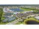 An aerial view shows a community with tennis courts, a pool, clubhouse, and lake at 14184 Heritage Landing Blvd # 513, Punta Gorda, FL 33955