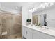 Bathroom with dual sinks, a glass-enclosed shower, and neutral tile at 14184 Heritage Landing Blvd # 513, Punta Gorda, FL 33955