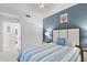 Bright bedroom with blue accent wall, comfortable bed, and access to a bathroom at 14184 Heritage Landing Blvd # 513, Punta Gorda, FL 33955