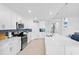 Modern white kitchen with stainless steel appliances, subway tile backsplash, and large island at 14184 Heritage Landing Blvd # 513, Punta Gorda, FL 33955
