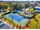 Aerial view of a tennis court, swimming pool and manicured grounds at 14519 Catalina Cir, Seminole, FL 33776