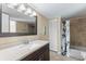 Bathroom featuring modern vanity and mirror, along with a tiled shower and a white closet door at 14519 Catalina Cir, Seminole, FL 33776