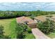 Stunning aerial view of the home with lush landscaping, a brick driveway, and a beautiful tile roof at 157 Wandering Wetlands Cir, Bradenton, FL 34212