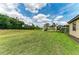 Expansive backyard features lush green grass and mature trees offering serene pond views and a private oasis at 157 Wandering Wetlands Cir, Bradenton, FL 34212