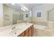 Well-lit bathroom features double sinks, a soaking tub, and a glass enclosed shower at 157 Wandering Wetlands Cir, Bradenton, FL 34212