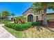 Welcoming clubhouse entrance with stone facade, ornate door, and tropical landscaping at 157 Wandering Wetlands Cir, Bradenton, FL 34212