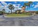 Circular driveway entrance to clubhouse is professionally landscaped with palms and flowers at 157 Wandering Wetlands Cir, Bradenton, FL 34212