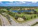Scenic aerial view of the community entrance featuring lush landscaping, a water feature, and well-maintained roadways at 157 Wandering Wetlands Cir, Bradenton, FL 34212