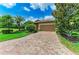 Beautiful residence featuring a terracotta roof, brick driveway, and well-manicured landscaping at 157 Wandering Wetlands Cir, Bradenton, FL 34212