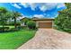 Inviting home showcasing meticulously maintained landscaping, a brick driveway, and a welcoming two-car garage at 157 Wandering Wetlands Cir, Bradenton, FL 34212